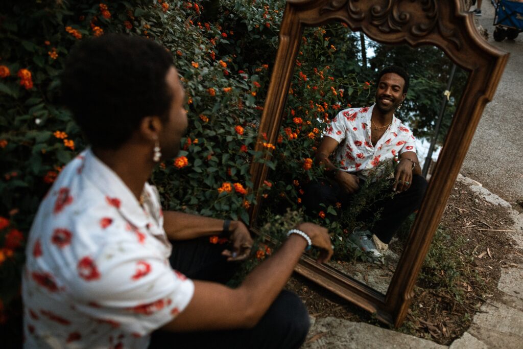 a well dressed person wearing a white button down shirt and posing in a mirror with flowers